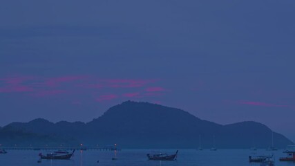 Wall Mural - A peaceful twilight scene at Rawai Beach in Phuket, featuring fishing boats anchored along the calm shoreline under a soft purple and blue sky.