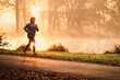 © baranq - Man jogging in park during autumn sunrise
