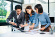 © laddawan - Asian business team brainstorming and discussing data charts in office, showing teamwork, planning, and collaboration