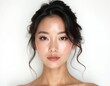 © miss irine - Young asian woman with fair skin and flawless makeup gazes forward. Her elegant hairstyle and delicate features highlight her natural beauty. Portrait shot on white background.