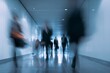 © Dina - Corporate hallway with blurred silhouettes walking quickly, motion blur effect. Business concept. Fast paced environment. Job market, search and career opportunities. Tough competition.