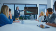 © Videophilia - Professional business people actively participating in a corporate meeting, analyzing financial data presented on a screen by an experienced male speaker in a modern office boardroom