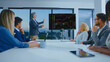 © Videophilia - Group of diverse business professionals discussing financial data and analyzing stock market charts on a screen during a corporate presentation in a modern office meeting room