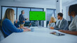 © Videophilia - Business executive presenting a new project idea or marketing strategy on a large chroma key display to a diverse group of attentive colleagues during a modern office meeting