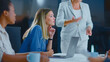 © Videophilia - Businesswomen attending a corporate briefing, listening intently to a female speaker presenting during a professional team meeting in a modern office environment