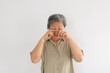 © Suthida - Thai elderly woman rubbing both eyes with fingers, sleepy isolated over white background