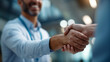 © Kateryna - Close cropped image of male doctor greeting clinic patient with handshake sleeves and IDs sharp backdrop defocused clinical greeting faceless background defocused welcome pro
