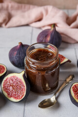 Wall Mural - Jar of sweet fig jam with spoon on white tile table