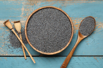 Wall Mural - Bowl and spoon with poppy seeds on blue wooden background