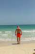 © travelview - attractive senior man at the beautiful sandy beach in swim suit