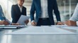 © Somkid - A team of professionals discusses documents in a modern office setting, emphasizing collaboration and strategic planning.