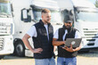 © Serhii - Two men managing logistics with truck fleet