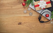 © kucherav - Holiday workspace with laptop, headset, wrapped gift and ornaments on wooden desk, background for Christmas customer service, remote work promos and seasonal marketing