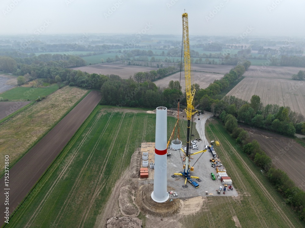 Heavy-duty crane places concrete part on the tower for a wind turbine ...