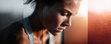Intense closeup shot of a sweaty woman looking down, possibly after exercise. Depicts dedication, effort, and physical fitness. Ideal for health, sports or wellbeing themes.
