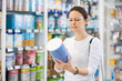 © JackF - Adult woman buyer in casual clothes chooses baby formula in pharmacy