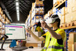 © DC Studio - Worker uses virtual reality headset to ensure order fulfillment with AI, tracking parcel status for e-commerce logistics. Asian man wears hi vis vest in industrial depot with racks and boxes.