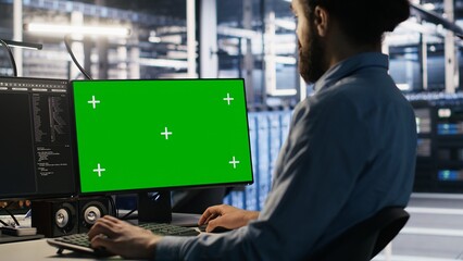 Data center technician doing software updates using green screen mockup computer. Server room IT specialist , optimizing infrastructure using chroma key isolated screen PC, camera A