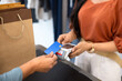 © fizkes - Fashion shop customer woman making payment by credit card