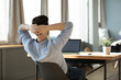 © fizkes - Rear view relaxed businessman reclining back on chair before laptop