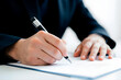 © Maikel - Empresario firmando un dBusinessman Writing on Notebook in Formal Suitocumento legal