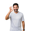 © velikiyzayats - Happy middle-aged man in a white t-shirt making an OK gesture, showing approval and confidence with a cheerful smile on a black background.