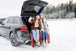 © maxbelchenko - Two young women take selfies with phones while sitting in trunk of car on sunny winter day. Beautiful friends have fun, blog, enjoy road trip through snowy forest. Concept of friendship, adventure.