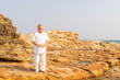 © CandyRetriever  - Asian senior man practicing meditation yoga on coastline mountain cliff at summer sunset. Elderly person enjoy outdoor relaxing yoga exercise. Aged people mental healthcare wellness motivation concept