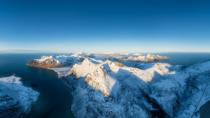 Wall Mural - Flight over the mountains. Scandinavia. Aerial view on the Lofoten Islands, Norway. Wide panoramic view of the north. Natural winter landscape from air. Photo for postcards, backgrounds, wallpapers.