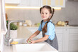 © New Africa - Little helper. Cute girl washing dishes in kitchen