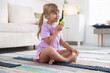 © New Africa - Little girl playing with walkie talkie toy at home