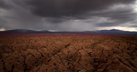 Wall Mural - Storm clouds brewing over dramatic desert terrain with lightning strike, aerial