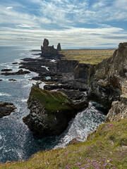 Wall Mural - Rocky cliff coastline of Iceland in summer.