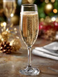 © SashaMagic - Champagne flute with bubbles on a festive holiday table.