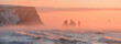 © Travel 'n' Lifestyle - View of the sun's gentle glow paints the misty horizon, casting a warm, ethereal light upon the rugged cliffs and the crashing waves of the sea, VÃ­k Ã­ MÃ½rdal, Iceland.