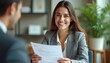© Pete - Cheerful woman smiles, holds cv document during job interview. Applicant presents resume to manager. Businesswoman attends meeting, looks happy. Pro woman seeks employment. Hiring event in workspace.