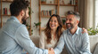 © Pete - Happy couple meets financial advisor at home. Shake hands, smiling, making deal, agreement. Man, woman get expert advice on finance, insurance, property, investment. Consultant helps clients with
