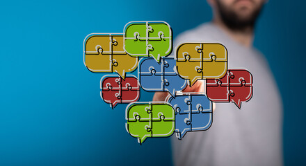A conceptual image of a man connecting speech bubbles composed of puzzle pieces, symbolizing teamwork, communication, and problem-solving.