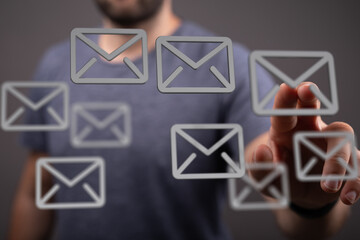 A man interacts with floating email icons, representing digital communication and inbox management.