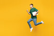 © ViDi Studio - Full body side view happy young man he wear green t-shirt casual clothes jump high hold in hand closed laptop pc computer isolated on plain yellow orange background studio portrait. Lifestyle concept.