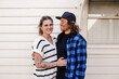 © Austockphoto - Happy couple standing outside white weatherboard home