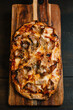 © ADDICTIVE STOCK - Rustic Italian pizza with savory toppings on wooden board