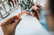 © ADDICTIVE STOCK - Female technician crafting dentures with precision