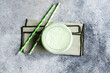 © ADDICTIVE STOCK - Refreshing matcha latte with straws on a gray background