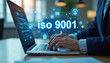 © miss irine - Businessman works on laptop with ISO 9001 standard on screen. Quality control in industry service. Management ensures compliance. Audit, inspection for company policy. Certification, standardization