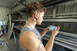 © ADDICTIVE STOCK - Trans man examining blueprint in workspace