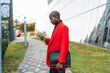 © ADDICTIVE STOCK - Young man in bright attire checking his phone outdoors