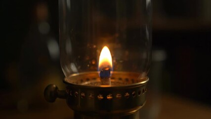 Wall Mural - A vintage oil lamp's flame flickers and gradually diminishes as the oil level drops, showing the passage of time in an atmospheric timelapse drops, illumination, heat