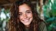 © JoxyAimages - A joyful young woman with curly hair and freckles smiles radiantly in a lush, green environment, showcasing her natural beauty and carefree attitude.