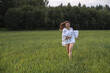 © shymar27 - Young woman with long hair wearing a white blouse is joyfully running through a green field, surrounded by trees, capturing the essence of freedom and happiness in nature